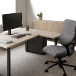 Un bureau en L met en valeur un coin de pièce en créant deux zones de travail distinctes. L’ensemble évoque un espace ergonomique, organisé et adapté à un usage intensif.