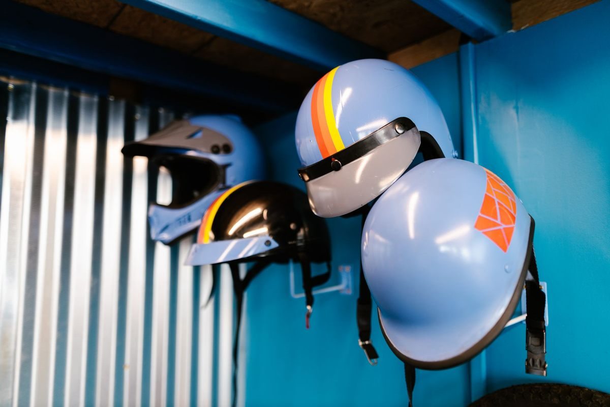 Casques de karting suspendus au mur d'un atelier aux murs bleus
