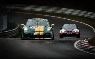 Voiture verte rayée jaune et voiture blanche rouge sur une piste de course
