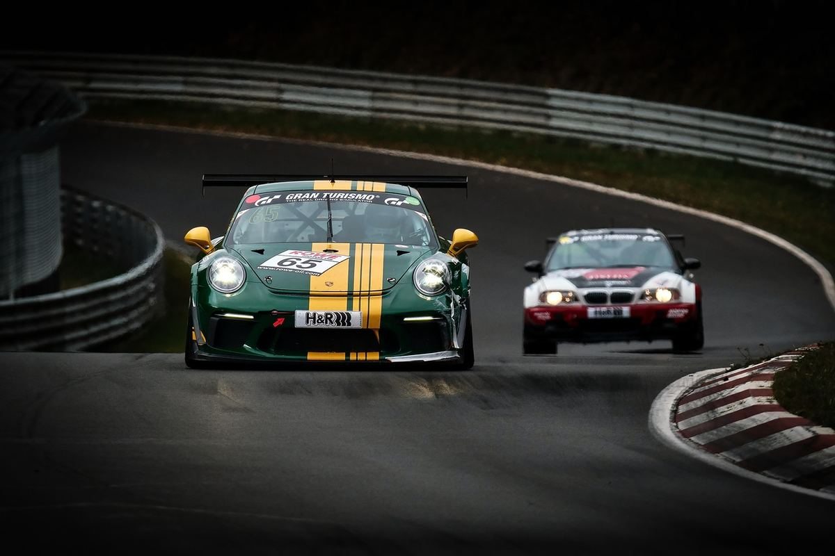 Voiture verte rayée jaune et voiture blanche rouge sur une piste de course