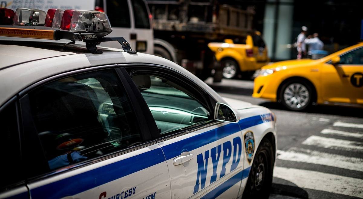 Voiture de police NYPD et taxi jaune sur une rue animée