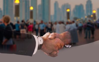 Deux hommes d'affaires en costume se serrent la main, gratte-ciel en arrière-plan