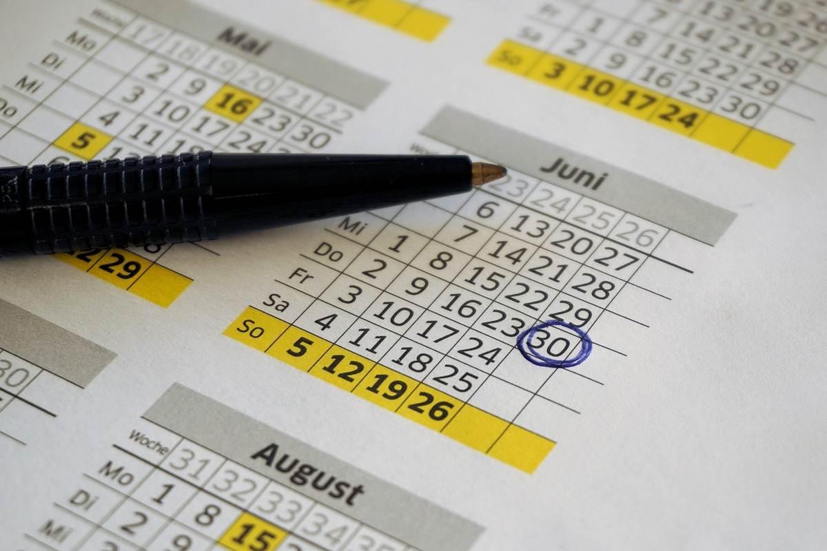 Un stylo pointe le 30 juin sur un calendrier affiché Un stylo pointe le 30 juin sur un calendrier affiché