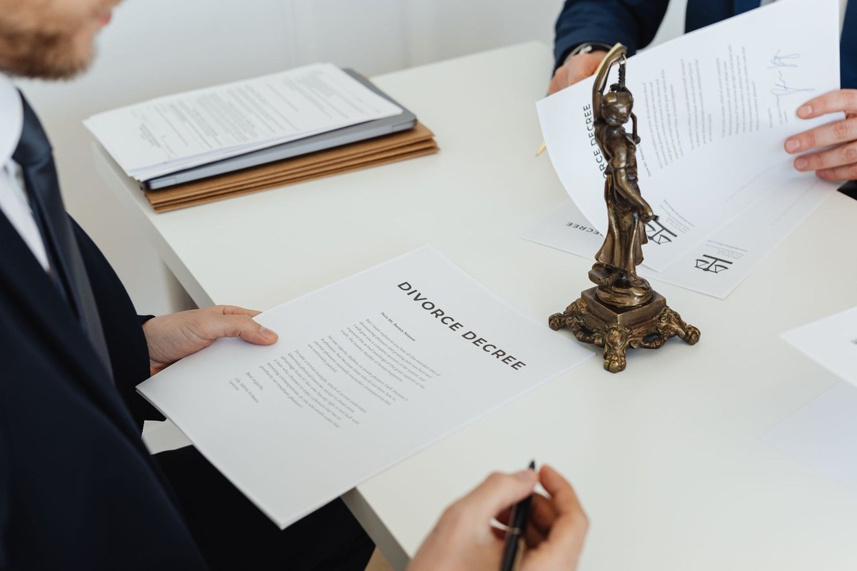 Individus en réunion professionnelle signant des papiers avec un trophée sur la table
