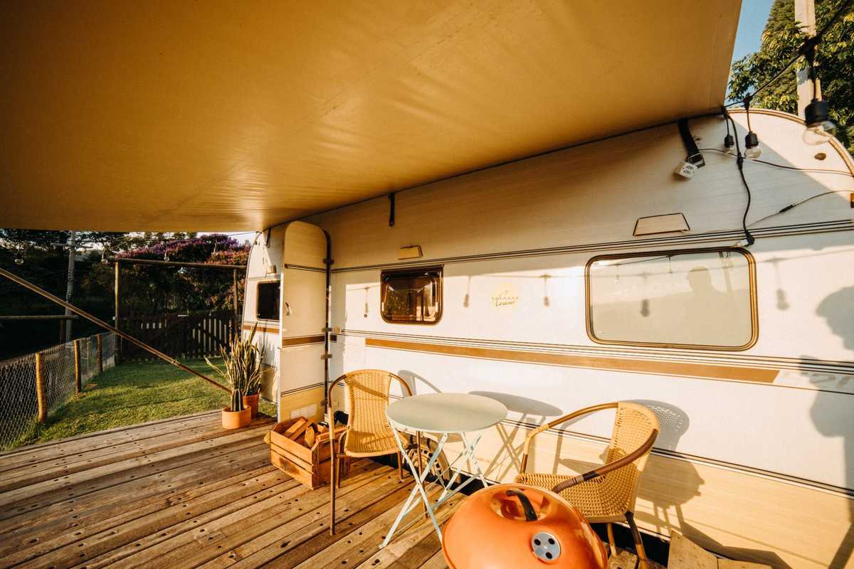 Terrasse en bois de mobil-home blanc avec auvent jaune et mobilier de jardin Terrasse en bois de mobil-home blanc avec auvent jaune et mobilier de jardin