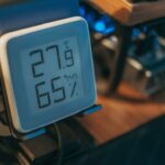 Thermomètre numérique affichant 27,9°C et 65% d'humidité sur table