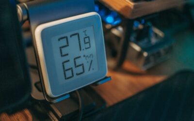 Thermomètre numérique affichant 27,9°C et 65% d'humidité sur table