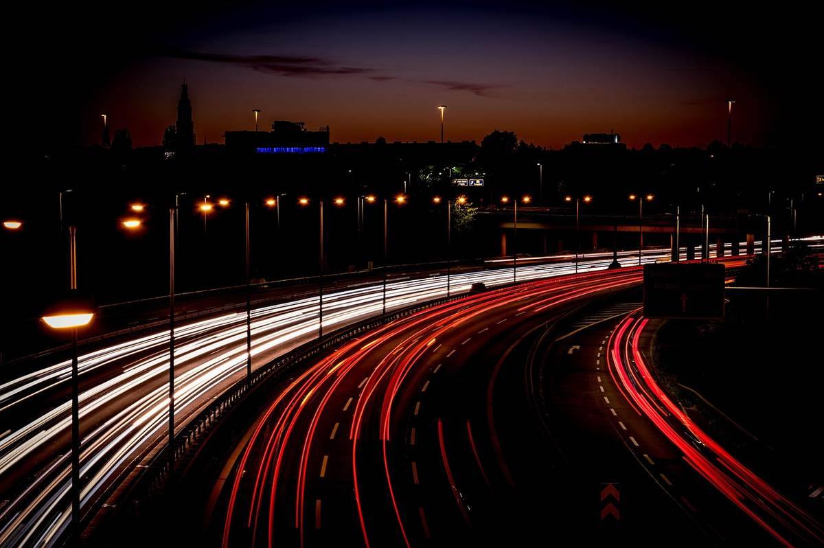 Traînées lumineuses de voitures sur une autoroute nocturne