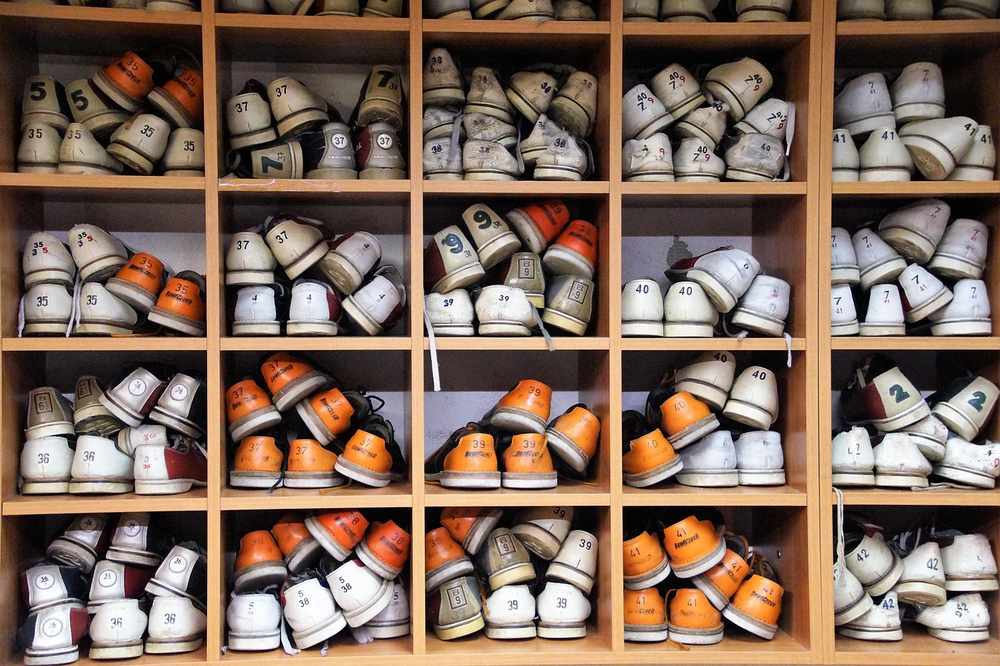 Des rangées de chaussures empilées sur des étagères en bois Des rangées de chaussures empilées sur des étagères en bois